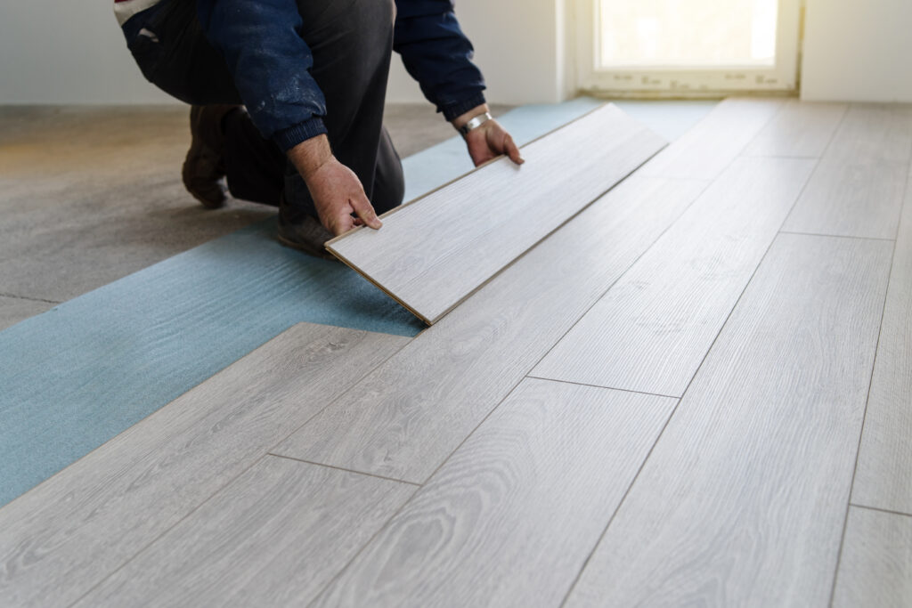 Flooring Installation services in Cape COD - Worker carpenter doing laminate floor work