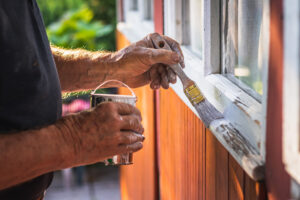 House improvement Senior craftsperson is painting wooden window