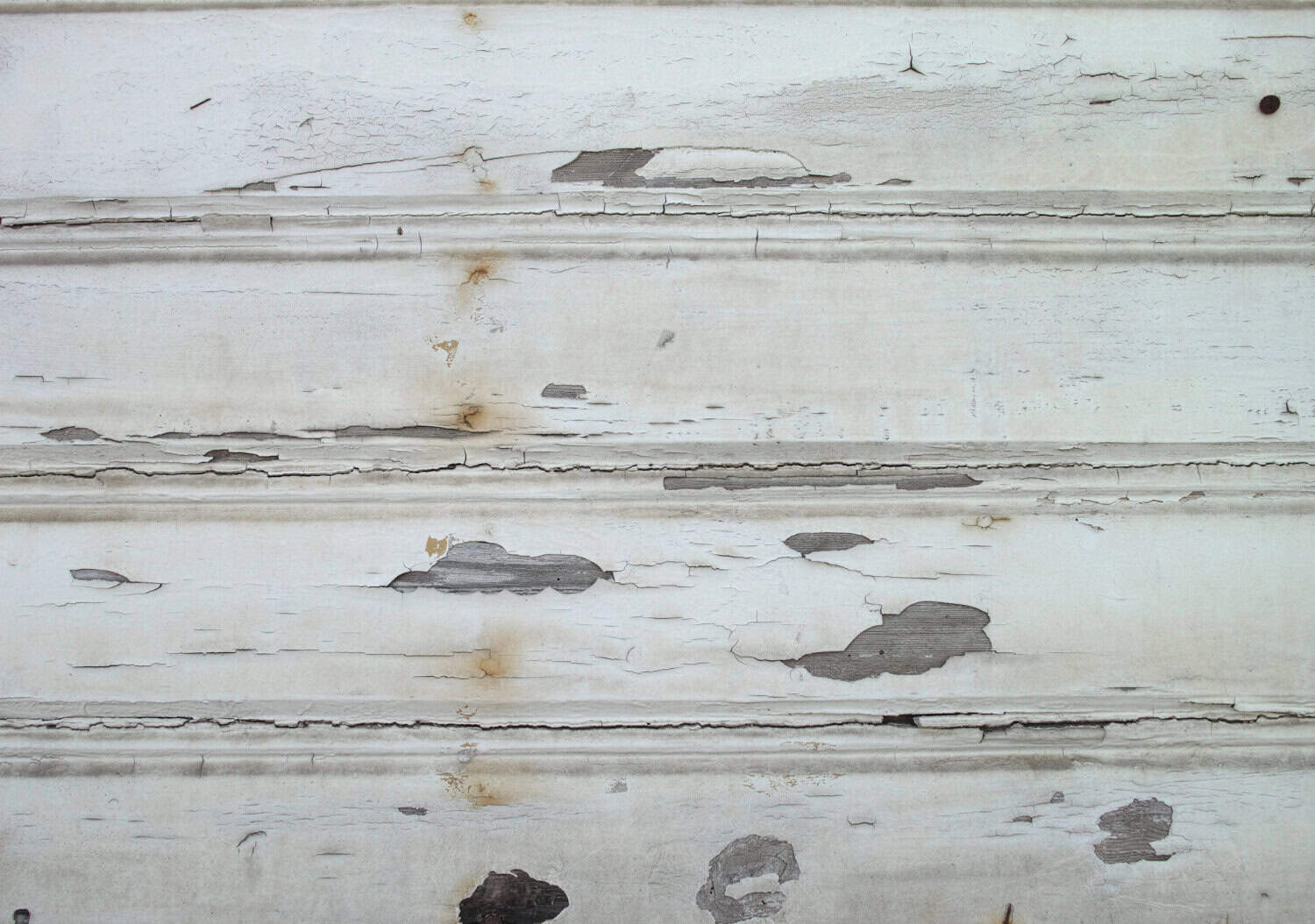 Close-up of weathered white siding with visible gaps, peeling paint, and signs of wear, relevant to home siding maintenance and repair.