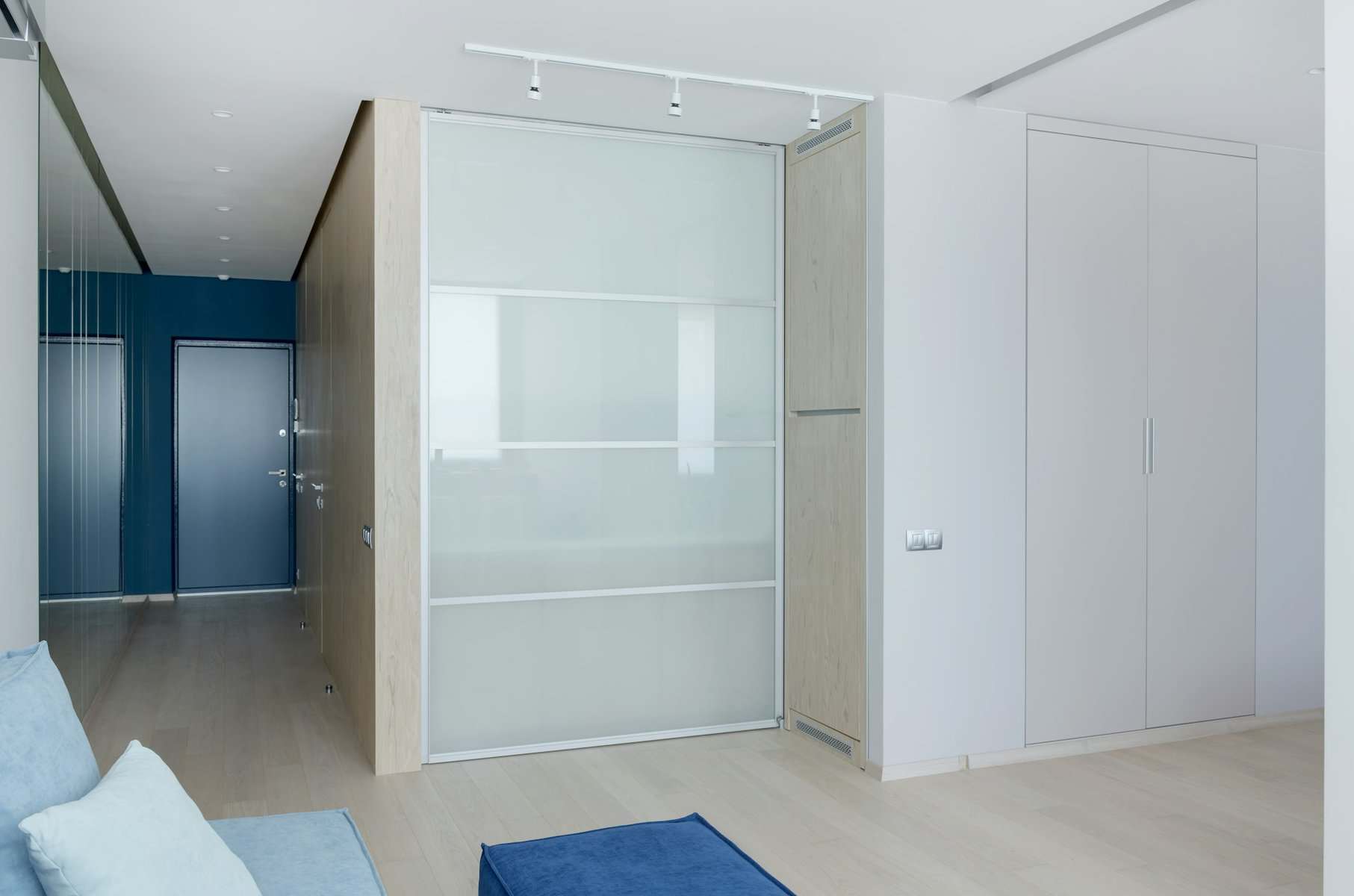 Modern interior space featuring sliding glass partition, light wood accents, and minimalist design elements, illustrating room addition concepts for residential construction.