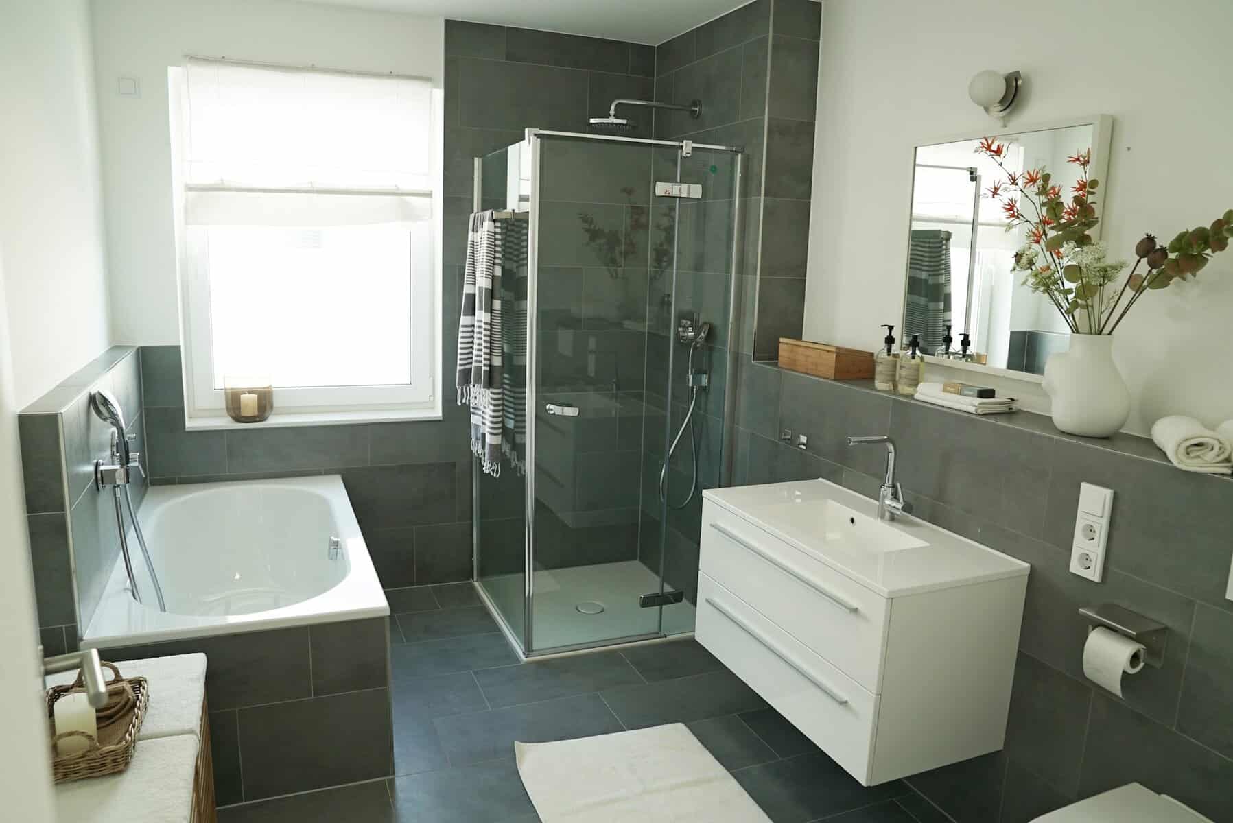 Modern bathroom interior featuring a freestanding bathtub, glass shower enclosure, and sleek vanity, emphasizing clean lines and contemporary design elements relevant to Cape Cod home remodeling.
