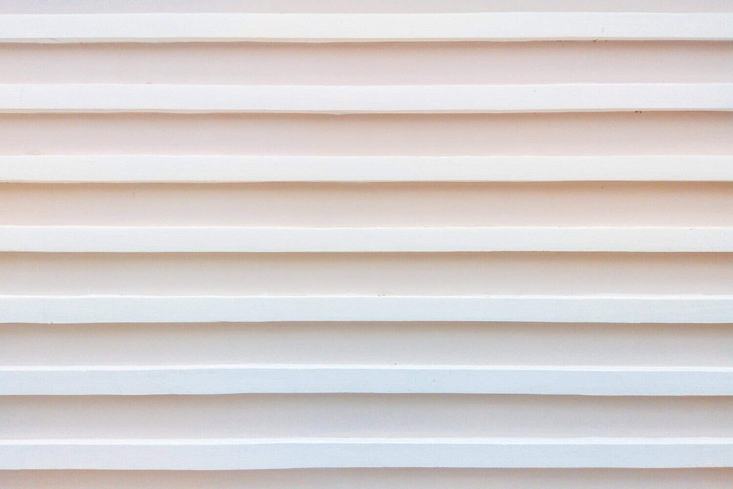 Warped white siding on a house, highlighting potential damage and maintenance issues relevant to Cape Cod homes.