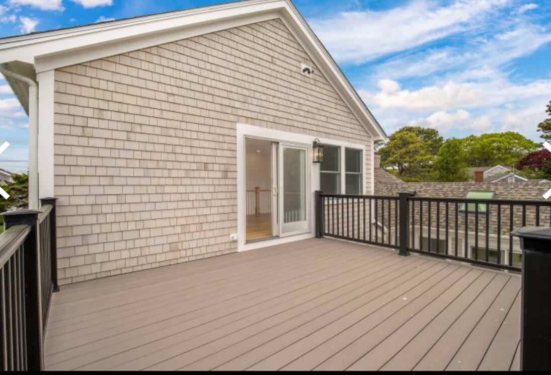 Finished Coast Carpentry deck on a Hyannis home, composite boards and white railings